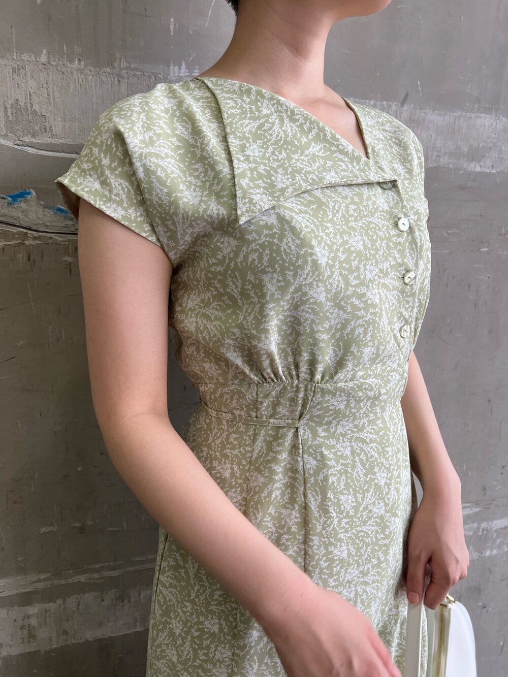 ベージュ系のサンダル、グリーン系のワンピース、ホワイト系のハンドバッグを着用したレディースの夏コーディネートの3枚目の写真