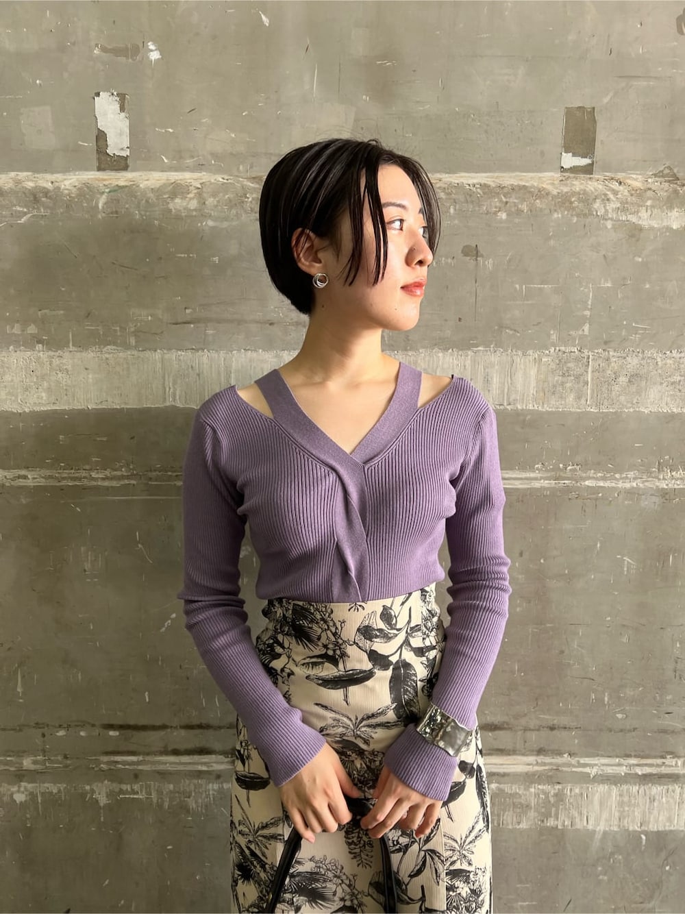 ベージュ系のスカート、ブラック系のブーツ、パープル系のニット/セーターを着用したレディースの秋コーディネートの4枚目の写真