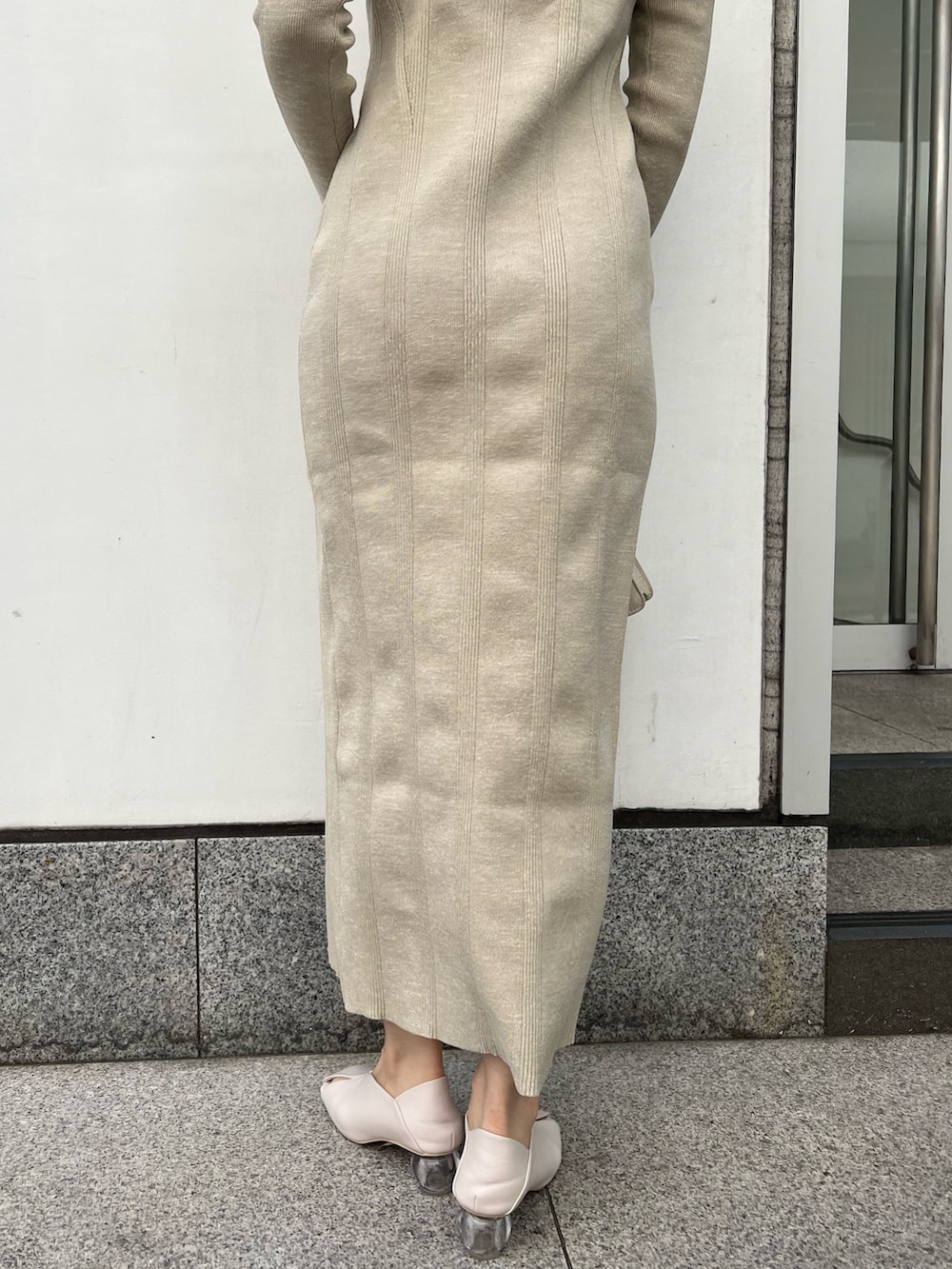 ホワイト系のパンプス、ベージュ系のワンピース、ホワイト系のショルダーバッグを着用したレディースの春コーディネートの6枚目の写真