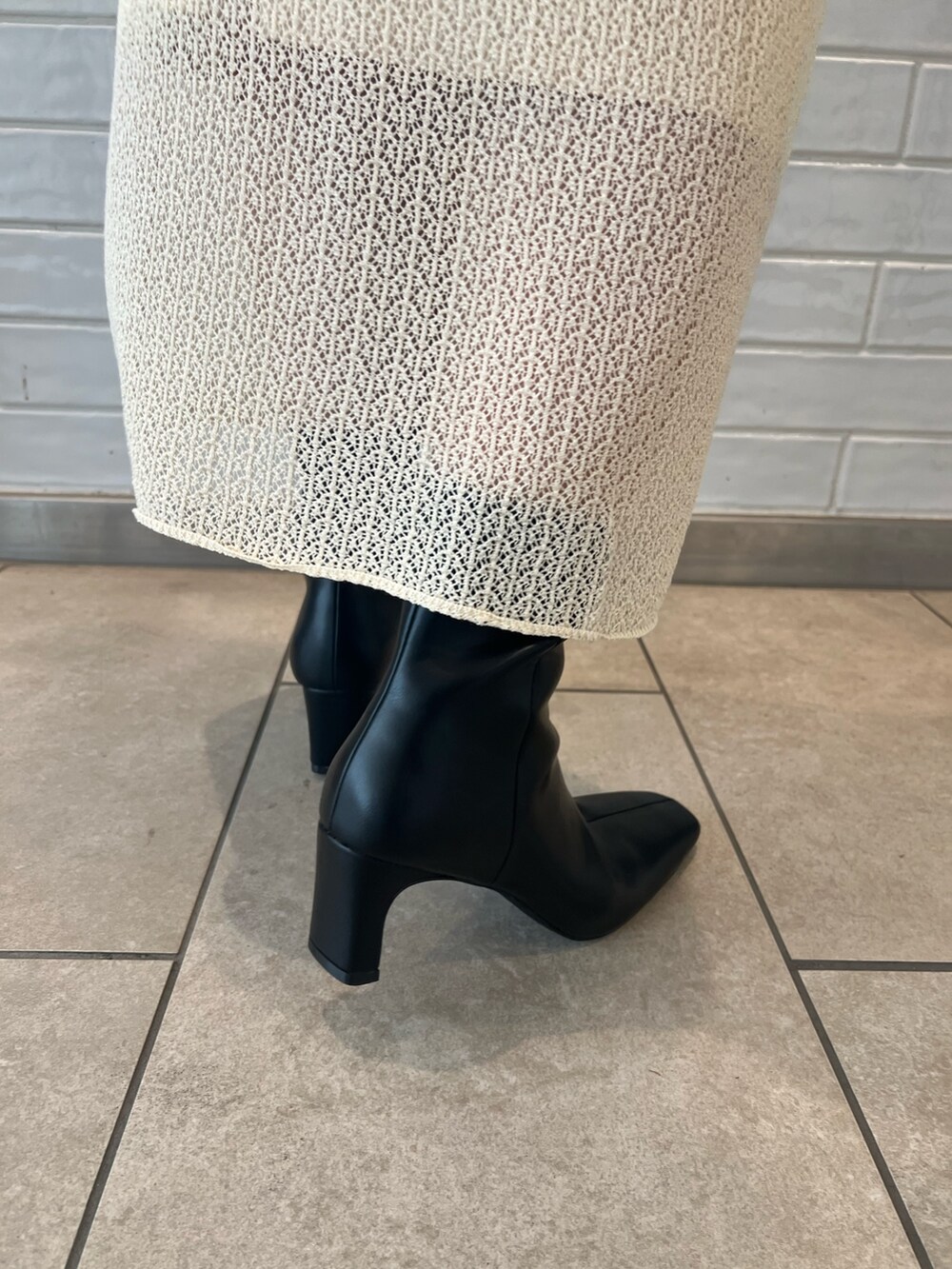 ホワイト系のワンピース、ブラック系のブーツ、ブラウン系のボディバッグ/ウエストポーチを着用したレディースの夏コーディネートの9枚目の写真