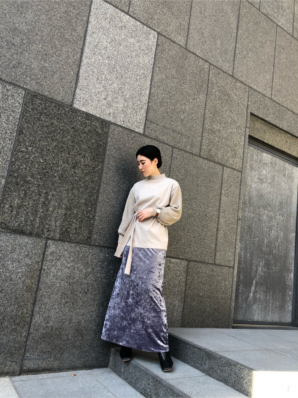 グレー系のスカート、ゴールド系のピアス（両耳用）を着用したレディースの冬コーディネートの2枚目の写真