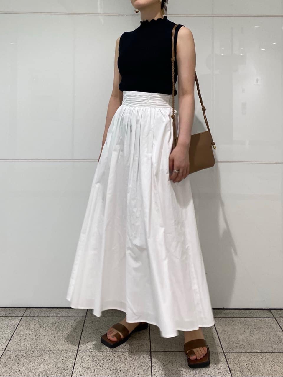 ブラウン系のサンダル、ブラック系のニット/セーター、ベージュ系のショルダーバッグを着用したレディースの夏コーディネートの6枚目の写真