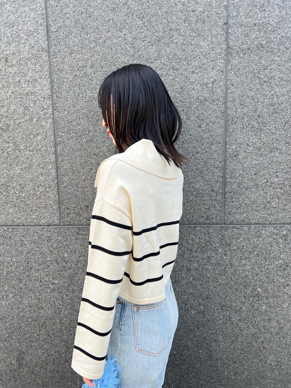 ブルー系のデニムパンツ、ホワイト系のニット/セーターを着用したレディースの冬コーディネートの5枚目の写真