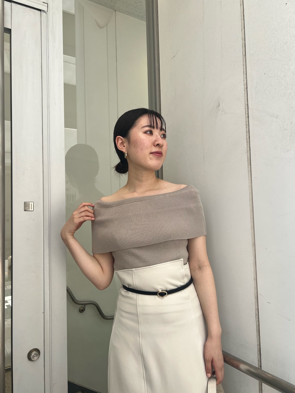 ホワイト系のショルダーバッグ、ホワイト系のスカート、ベージュ系のニット/セーターを着用したレディースの夏コーディネートの4枚目の写真