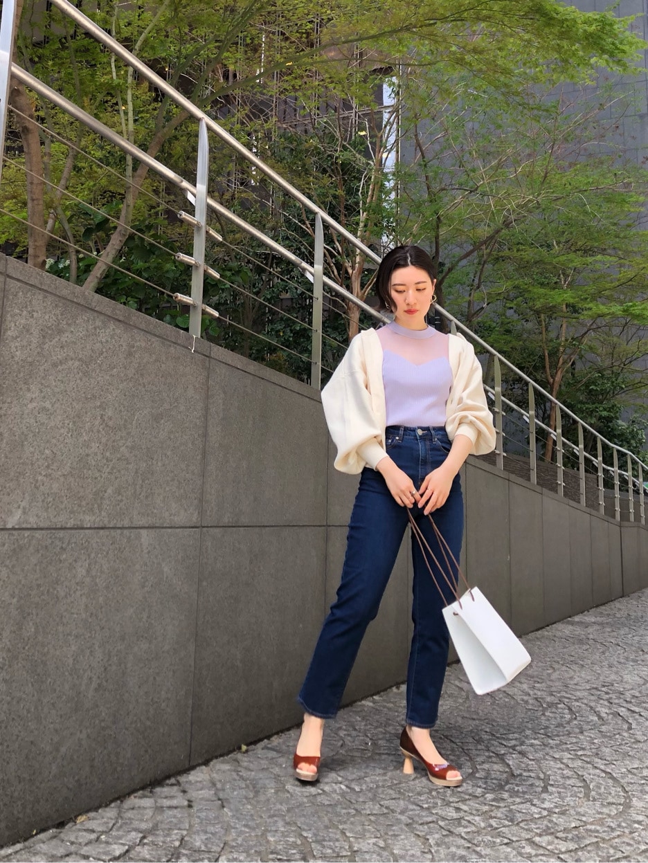 ブラウン系のパンプス、ブルー系のデニムパンツ、ホワイト系のハンドバッグを着用したレディースの春コーディネートの5枚目の写真