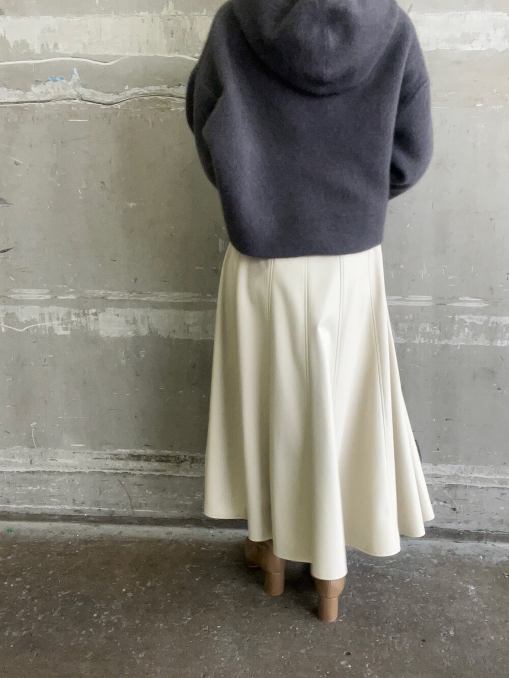 ベージュ系のブーツ、グレー系のパーカー、ホワイト系のスカートを着用したレディースの秋コーディネートの9枚目の写真