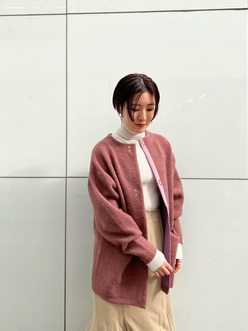 ベージュ系のスカート、ホワイト系のその他シューズ、ピンク系のカーディガン/ボレロを着用したレディースの冬コーディネートの5枚目の写真