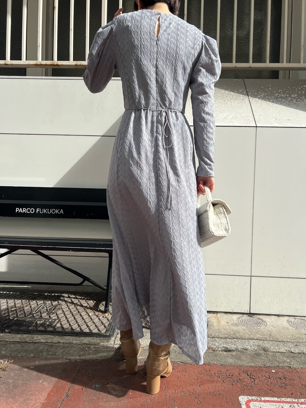 ホワイト系のショルダーバッグ、ベージュ系のブーツ、ベージュ系のその他アウターを着用したレディースの冬コーディネートの10枚目の写真