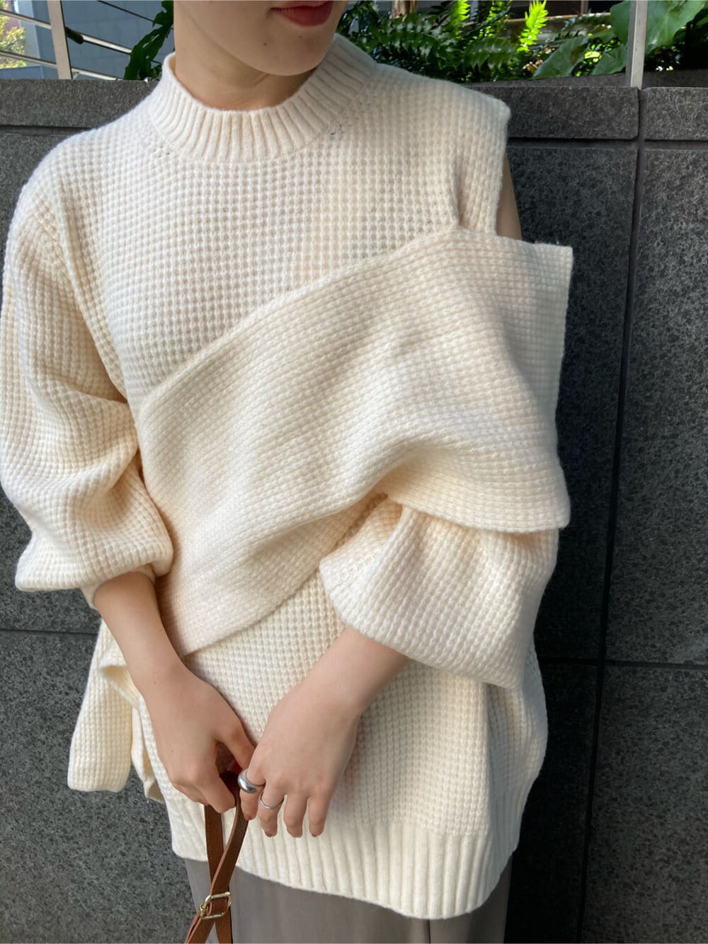 ベージュ系のスカート、ブラウン系のショルダーバッグ、ホワイト系のニット/セーターを着用したレディースの秋コーディネートの4枚目の写真