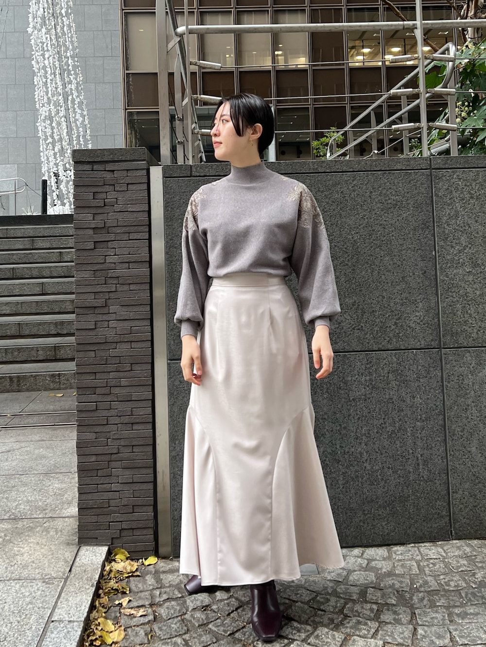 レッド系のブーツ、グレー系のスカート、グレー系のニット/セーターを着用したレディースの冬コーディネートの9枚目の写真