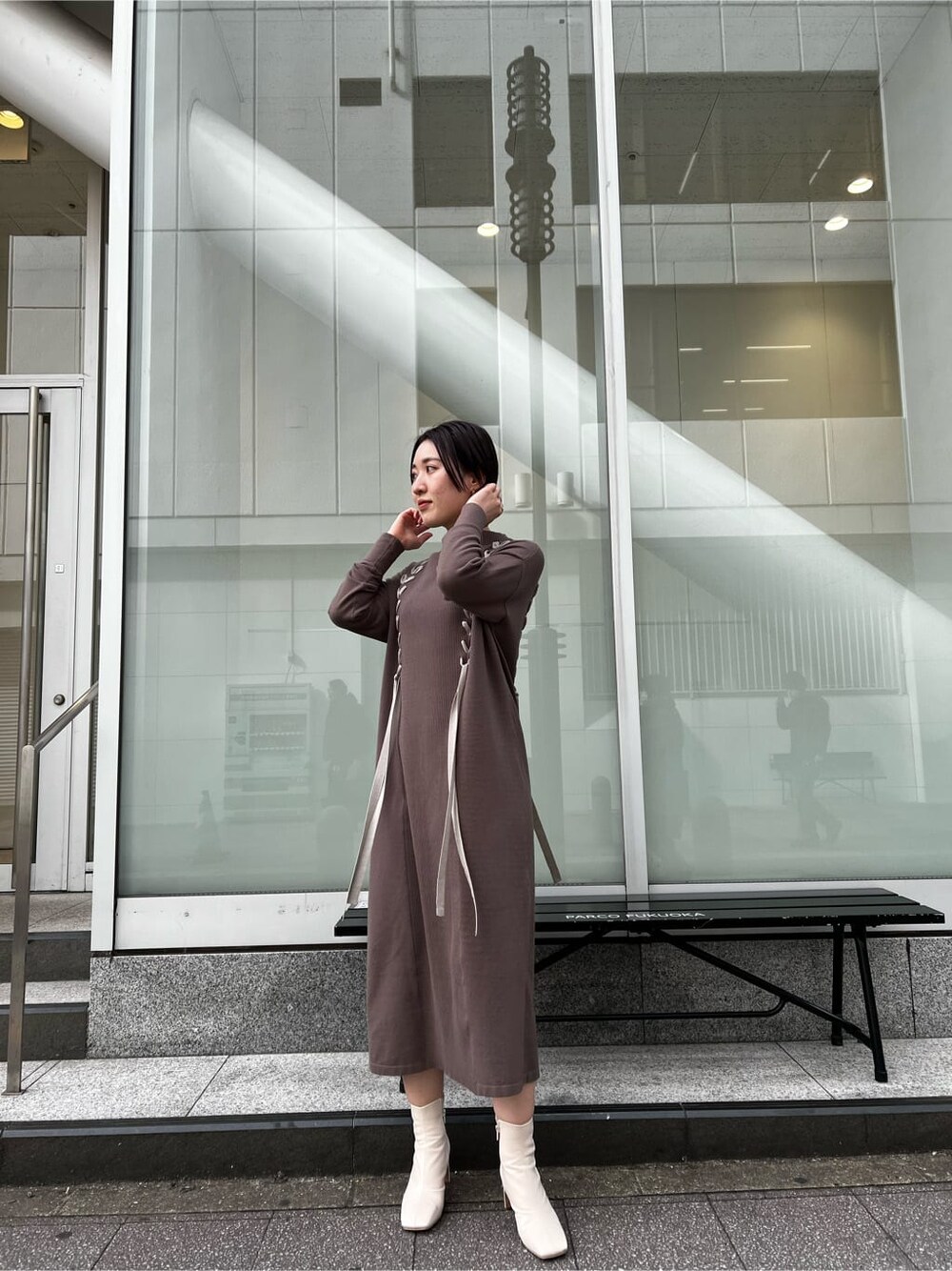 ベージュ系のその他アウター、ベージュ系のワンピース、ホワイト系のその他シューズを着用したレディースの冬コーディネートの2枚目の写真