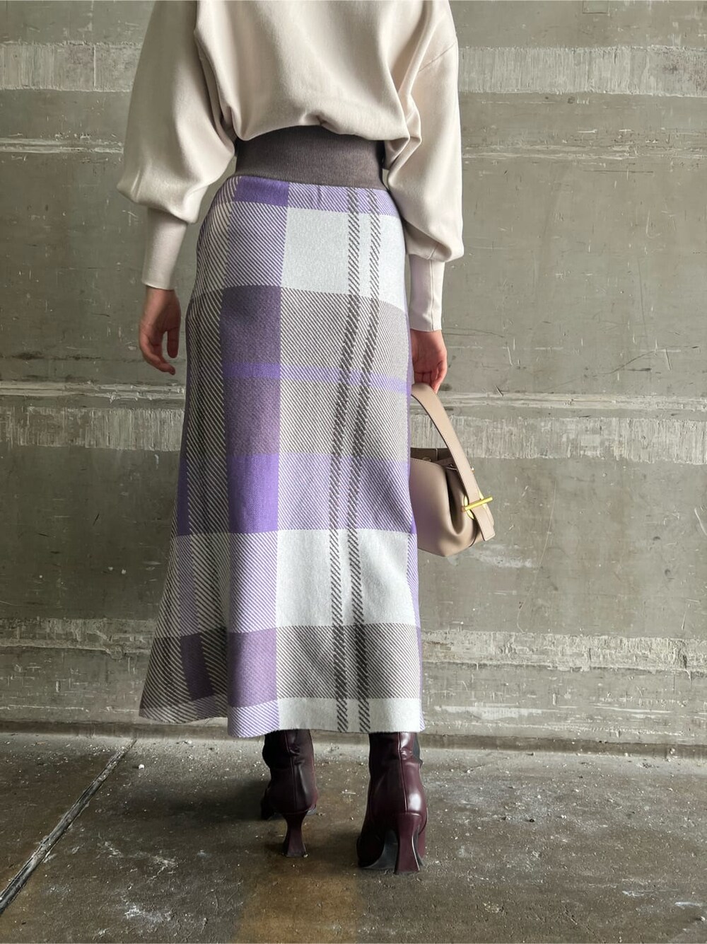 ホワイト系のニット/セーター、レッド系のブーツ、パープル系のスカートを着用したレディースの秋コーディネートの5枚目の写真