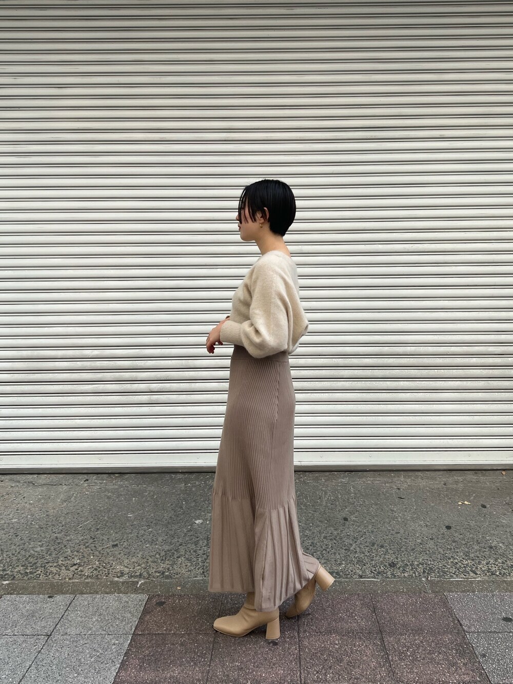 ピンク系のノーカラーコート、ホワイト系のワンピース、ベージュ系のブーツを着用したレディースの秋コーディネートの5枚目の写真