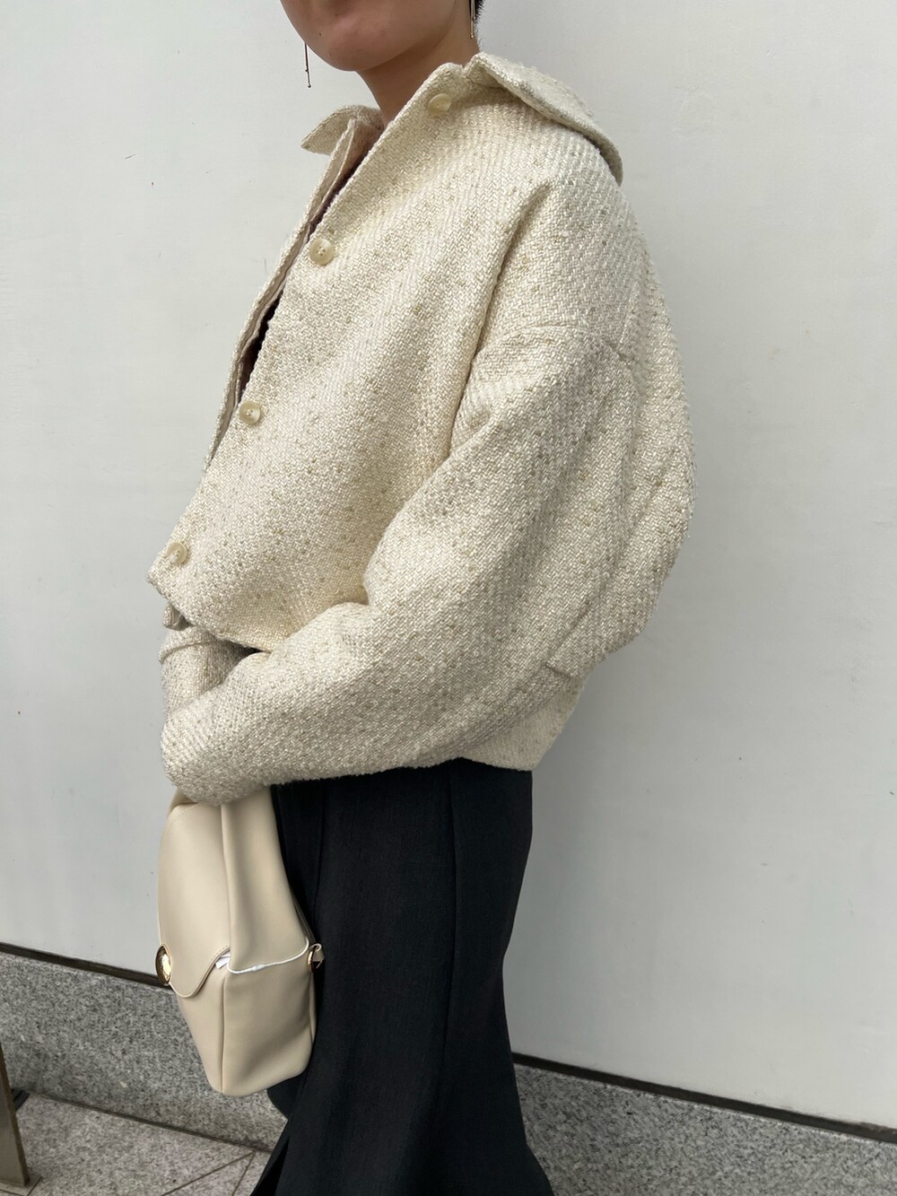 ホワイト系のハンドバッグ、グレー系のスカート、ベージュ系のブーツを着用したレディースの秋コーディネートの4枚目の写真