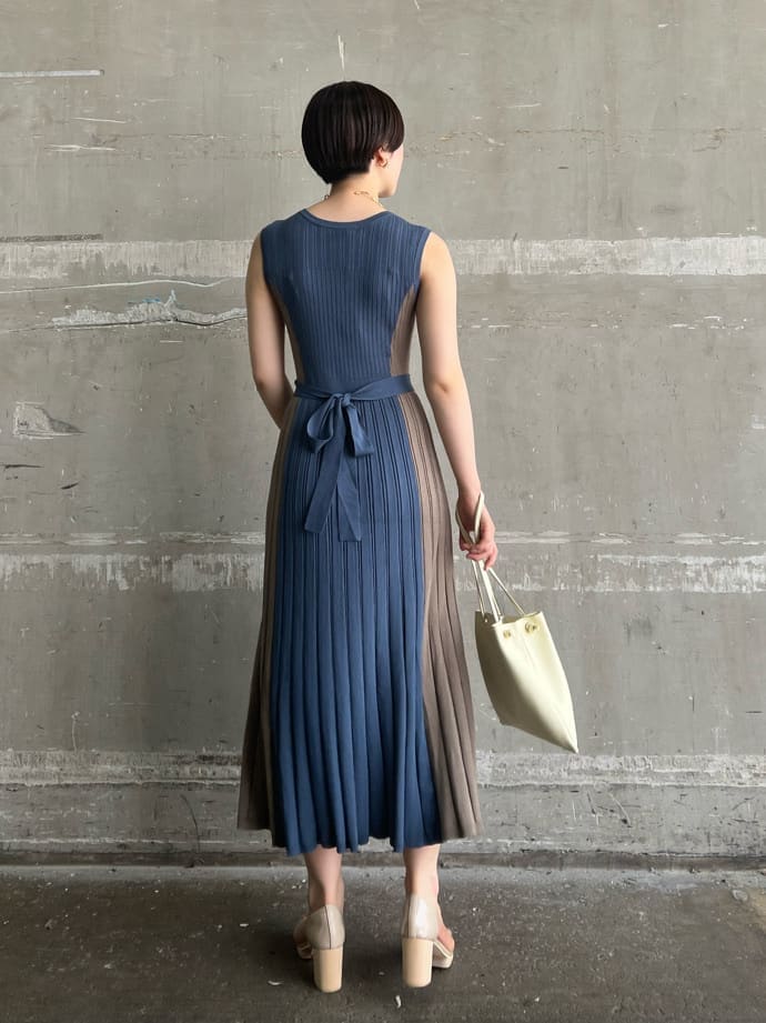 ホワイト系のハンドバッグ、ブルー系のワンピース、ゴールド系のピアス（両耳用）を着用したレディースの夏コーディネートの3枚目の写真