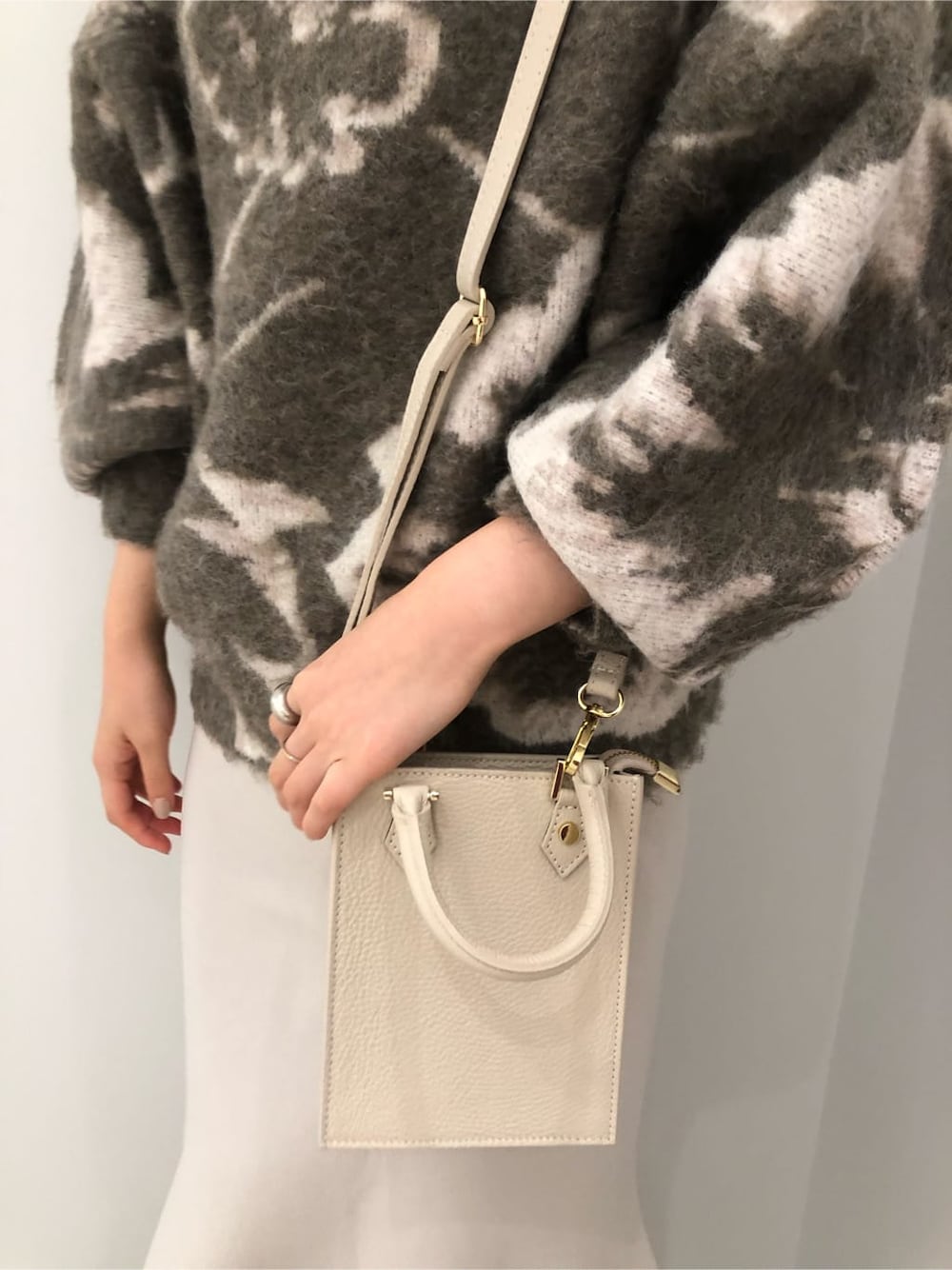 ベージュ系のその他シューズ、ホワイト系のショルダーバッグ、グレー系のスカートを着用したレディースの秋コーディネートの8枚目の写真