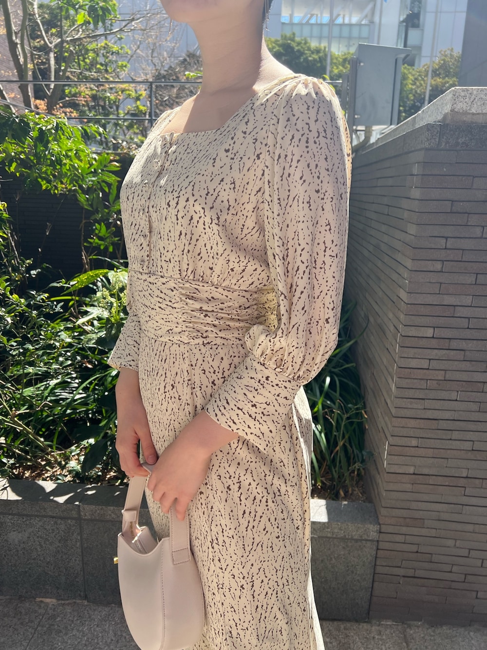 ホワイト系のハンドバッグ、ベージュ系のサンダル、ホワイト系のワンピースを着用したレディースの春コーディネートの9枚目の写真