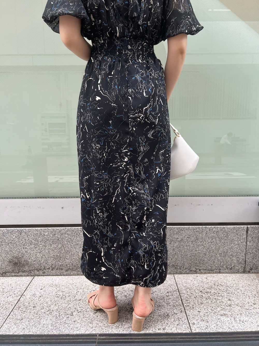 ベージュ系のサンダル、ホワイト系のハンドバッグ、ブラック系のワンピースを着用したレディースの夏コーディネートの7枚目の写真