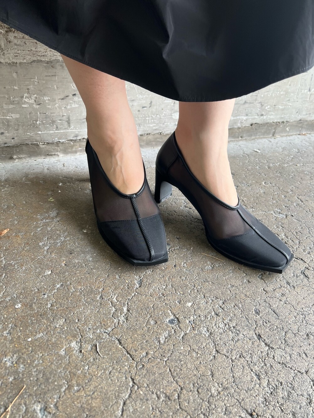 ホワイト系のハンドバッグ、ブラック系のワンピース、ブラック系のパンプスを着用したレディースの秋コーディネートの8枚目の写真