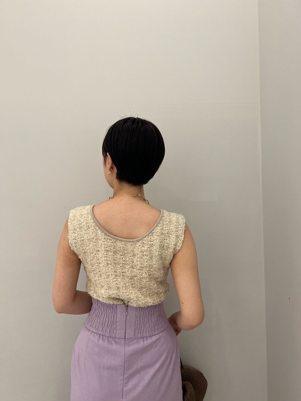 ホワイト系のハンドバッグ、ホワイト系のニット/セーター、パープル系のスカートを着用したレディースの春コーディネートの7枚目の写真