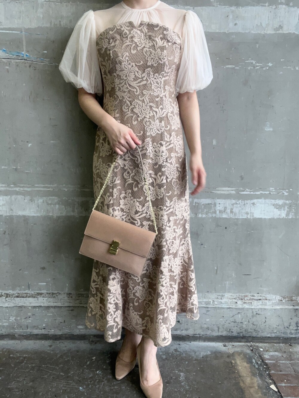 ベージュ系のドレス、ブラウン系のクラッチバッグ、ゴールド系のパンプスを着用したレディースの秋コーディネートの8枚目の写真