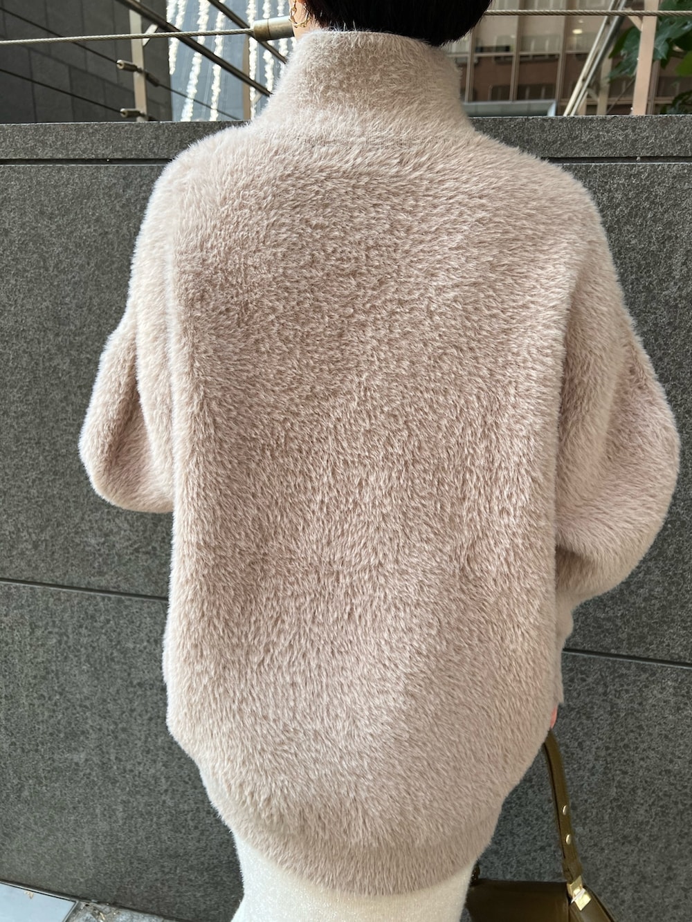 ブラウン系のショルダーバッグ、ブラウン系のニット/セーター、ベージュ系のブーツを着用したレディースの冬コーディネートの6枚目の写真