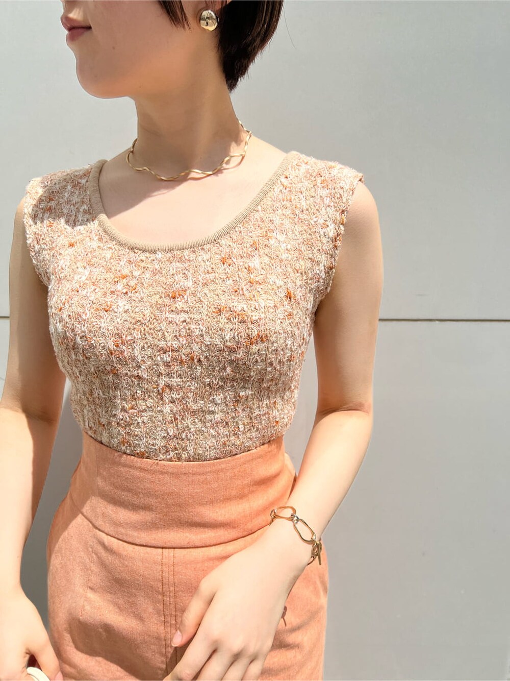 ホワイト系のハンドバッグ、オレンジ系のスカート、その他のパンプスを着用したレディースの春コーディネートの6枚目の写真