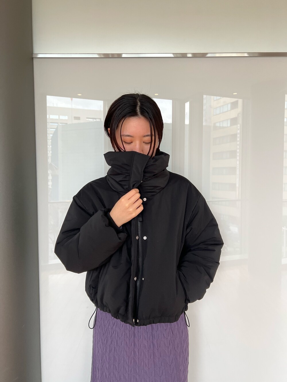 ブラック系のダウンジャケット/コート、ブラック系のブーツ、パープル系のワンピースを着用したレディースの冬コーディネートの4枚目の写真