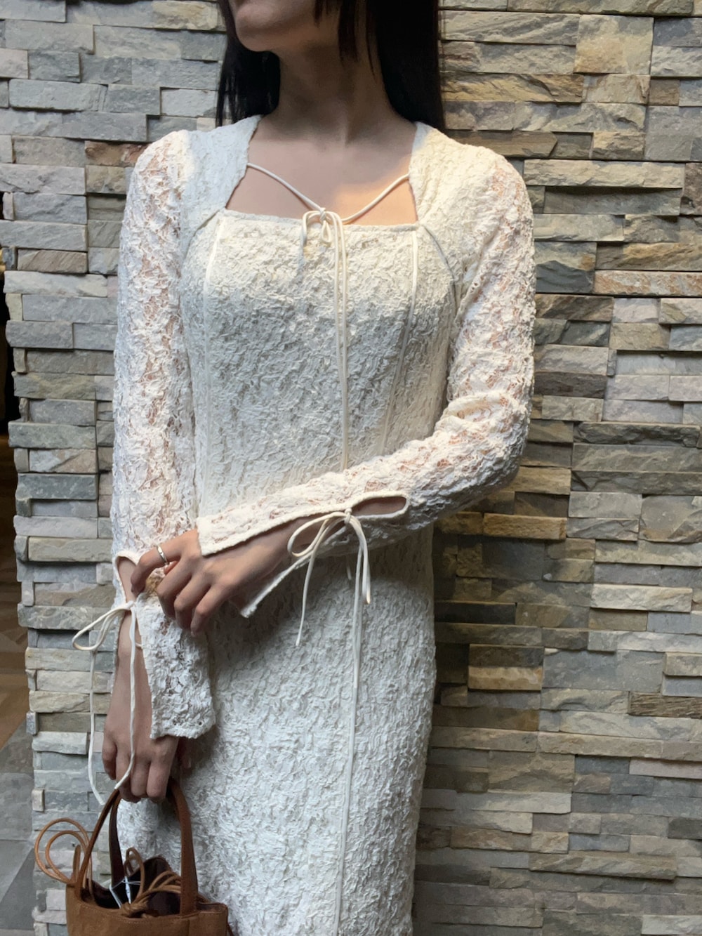 ホワイト系のワンピース、ブラウン系のハンドバッグ、シルバー系のパンプスを着用したレディースの冬コーディネートの4枚目の写真