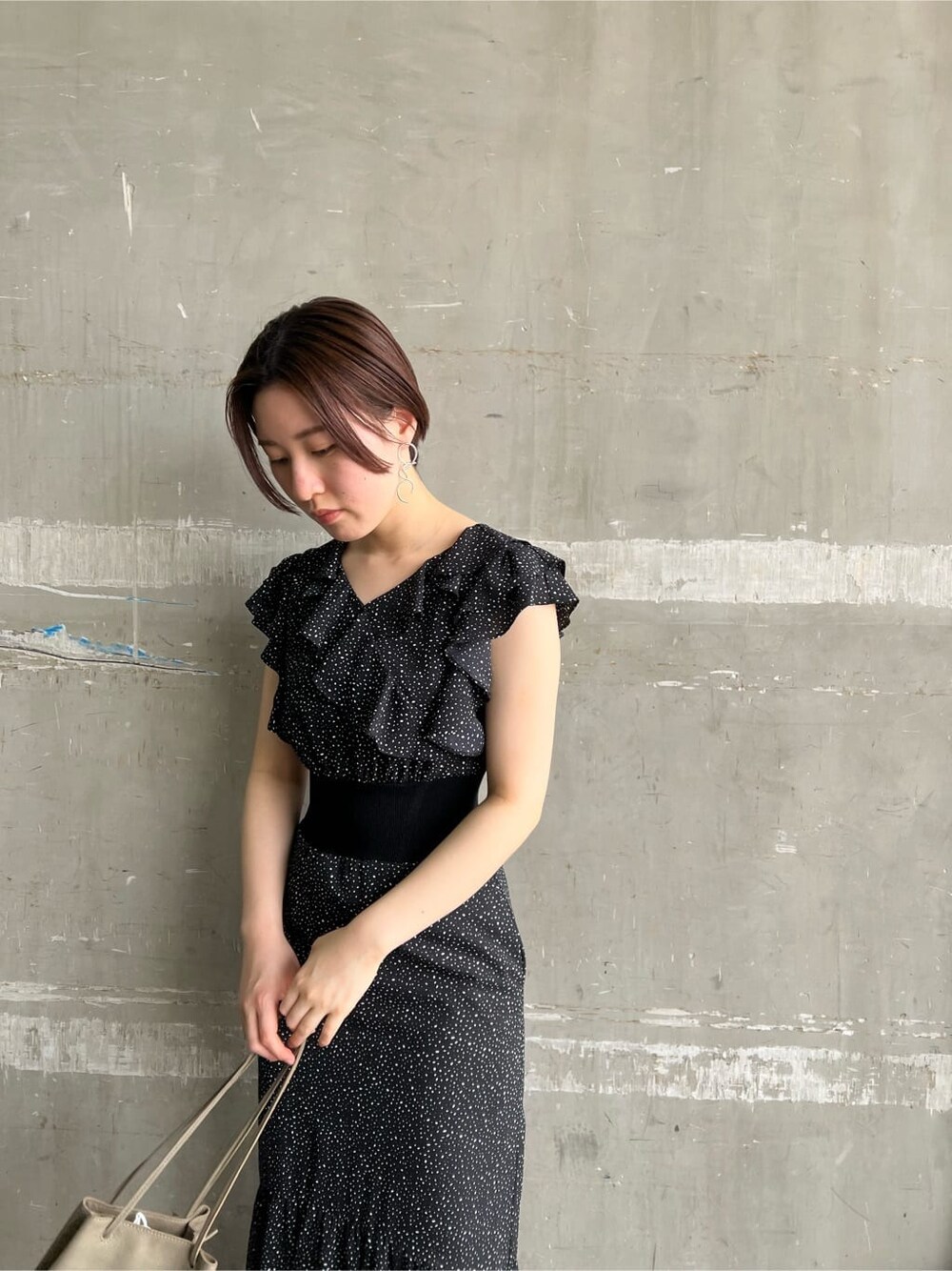 ベージュ系のハンドバッグ、ブラウン系のパンプス、ブラック系のワンピースを着用したレディースの夏コーディネートの7枚目の写真