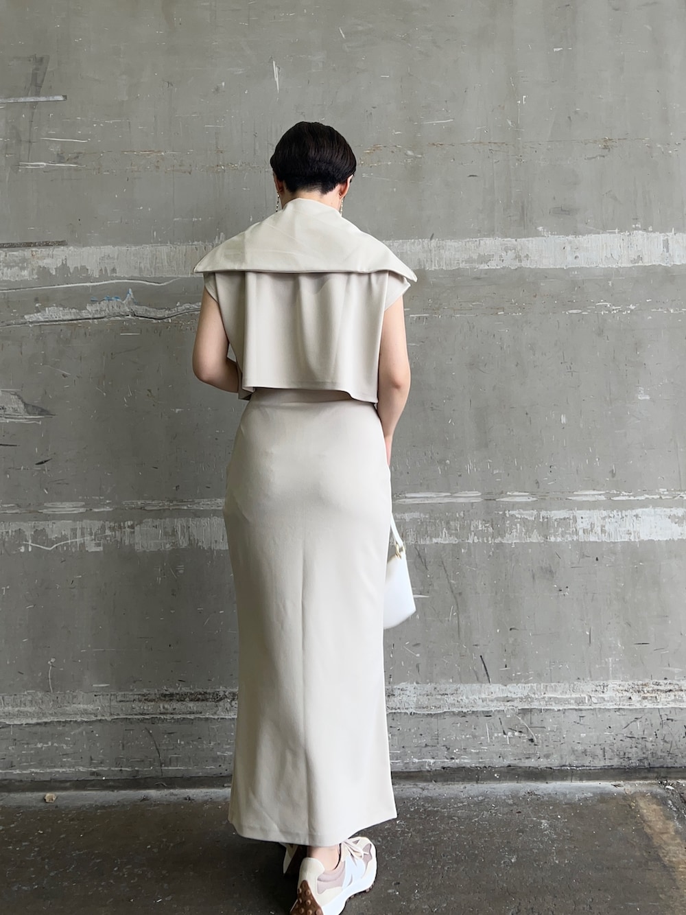 ホワイト系のハンドバッグ、ホワイト系のTシャツ/カットソー、ホワイト系のスカートを着用したレディースの夏コーディネートの3枚目の写真