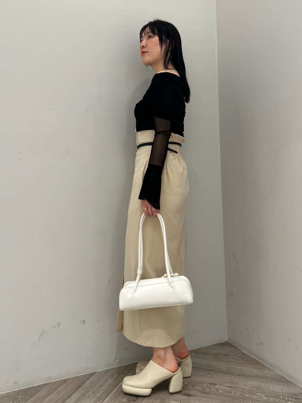 ホワイト系のサンダル、ベージュ系のスカート、ブラック系のTシャツ/カットソーを着用したレディースの春コーディネートの2枚目の写真