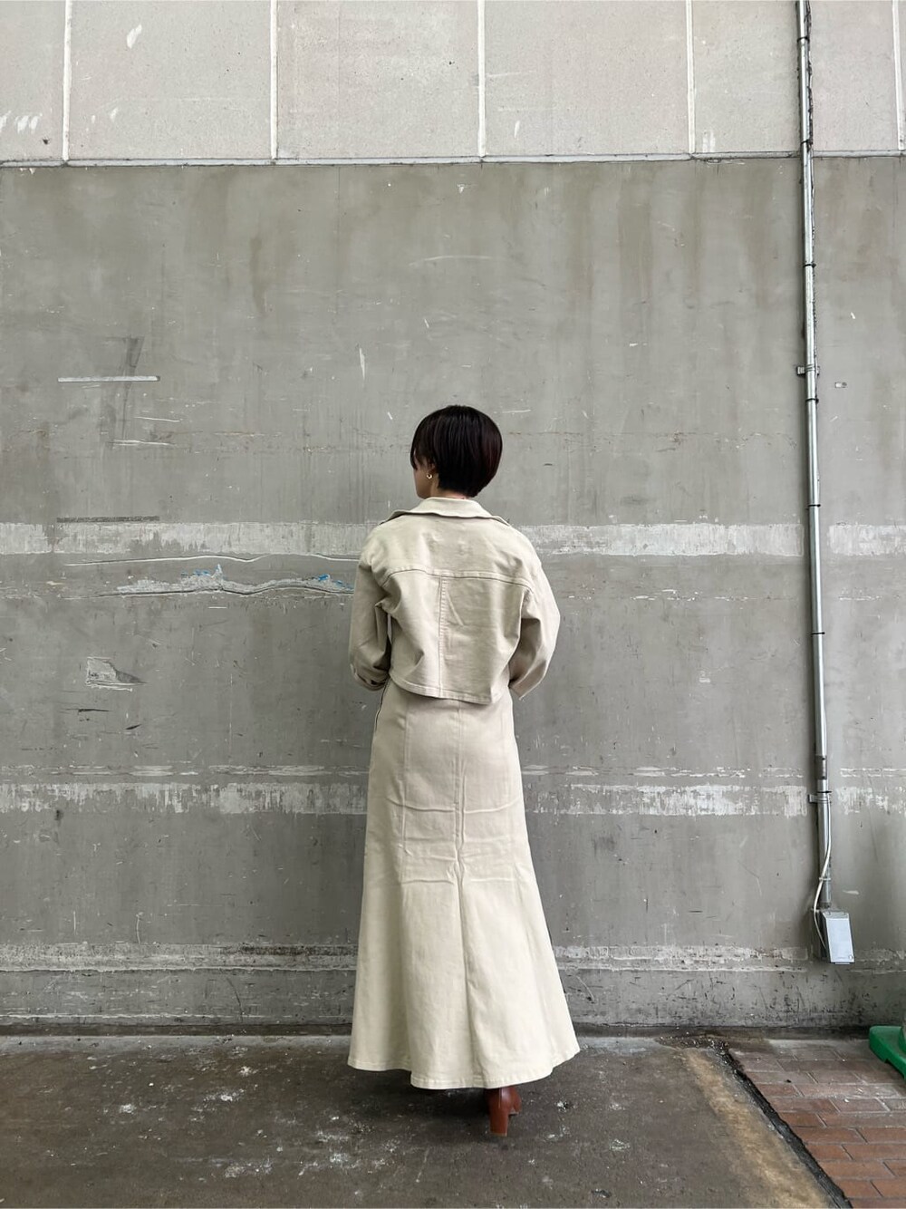 ブラウン系のパンプス、ベージュ系のデニムジャケット、ベージュ系のスカートを着用したレディースの夏コーディネートの3枚目の写真