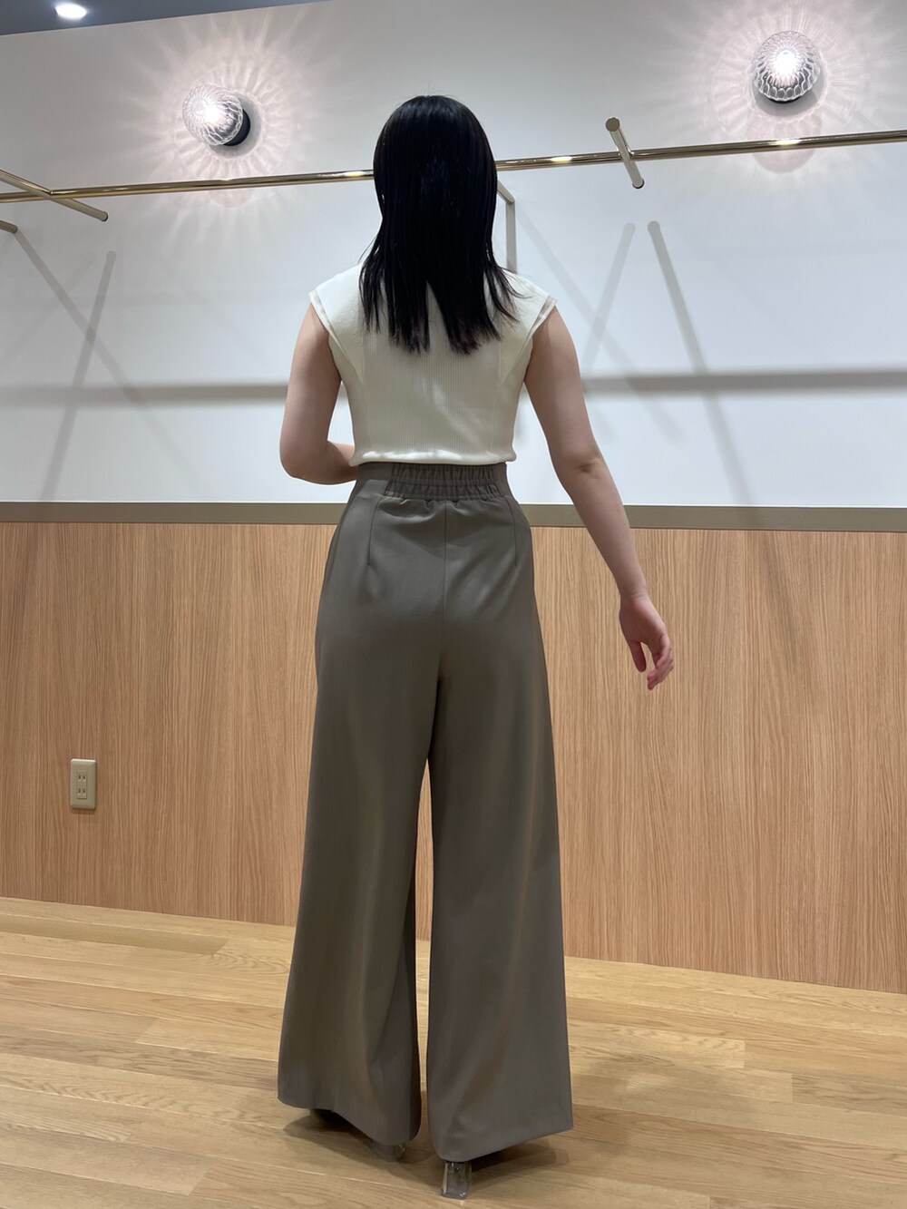 ブラウン系のその他パンツ、ブラック系のサンダル、ホワイト系のニット/セーターを着用したレディースの春コーディネートの3枚目の写真