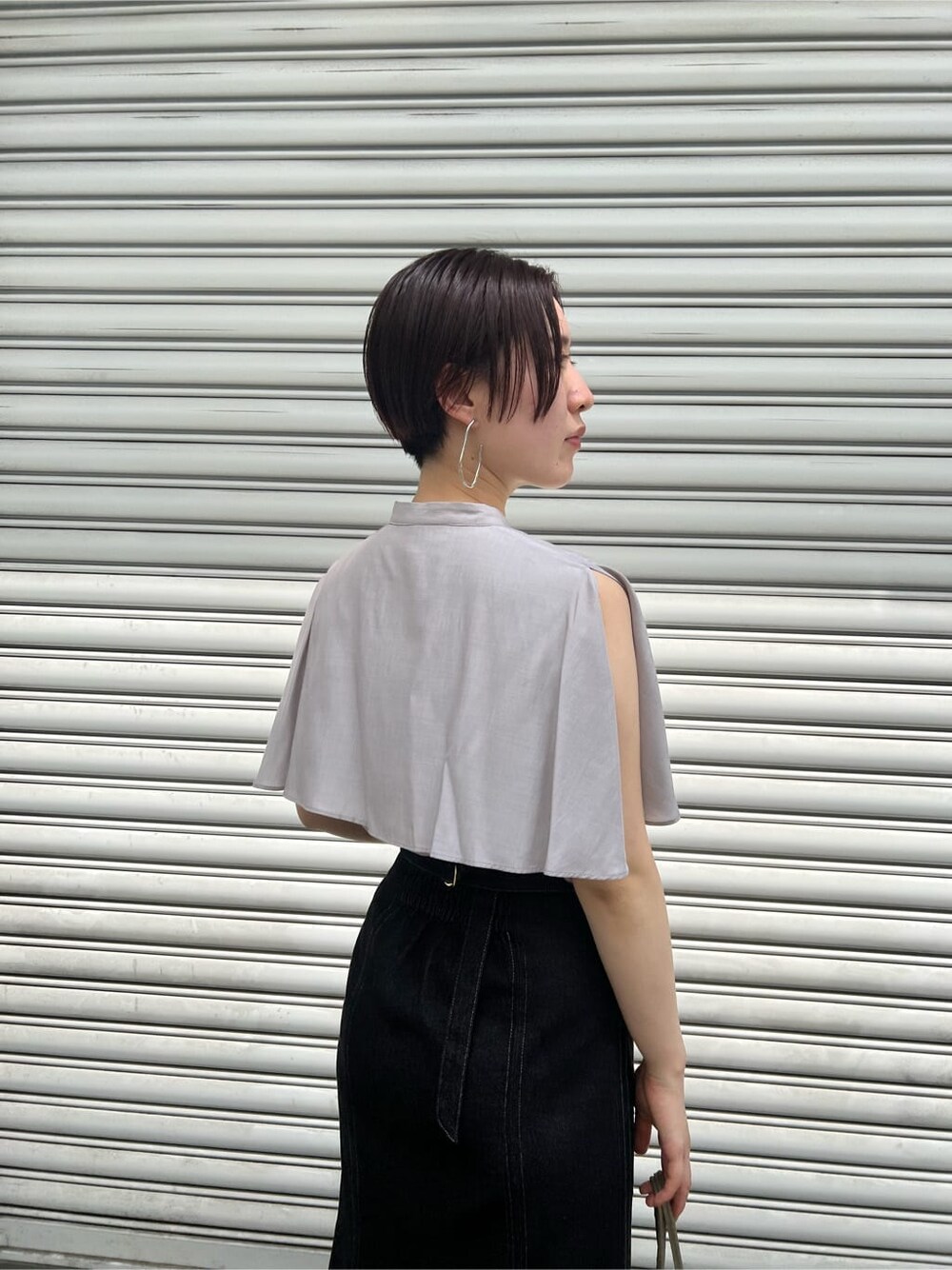 ベージュ系のハンドバッグ、ブラック系のスカート、その他のサンダルを着用したレディースの夏コーディネートの8枚目の写真