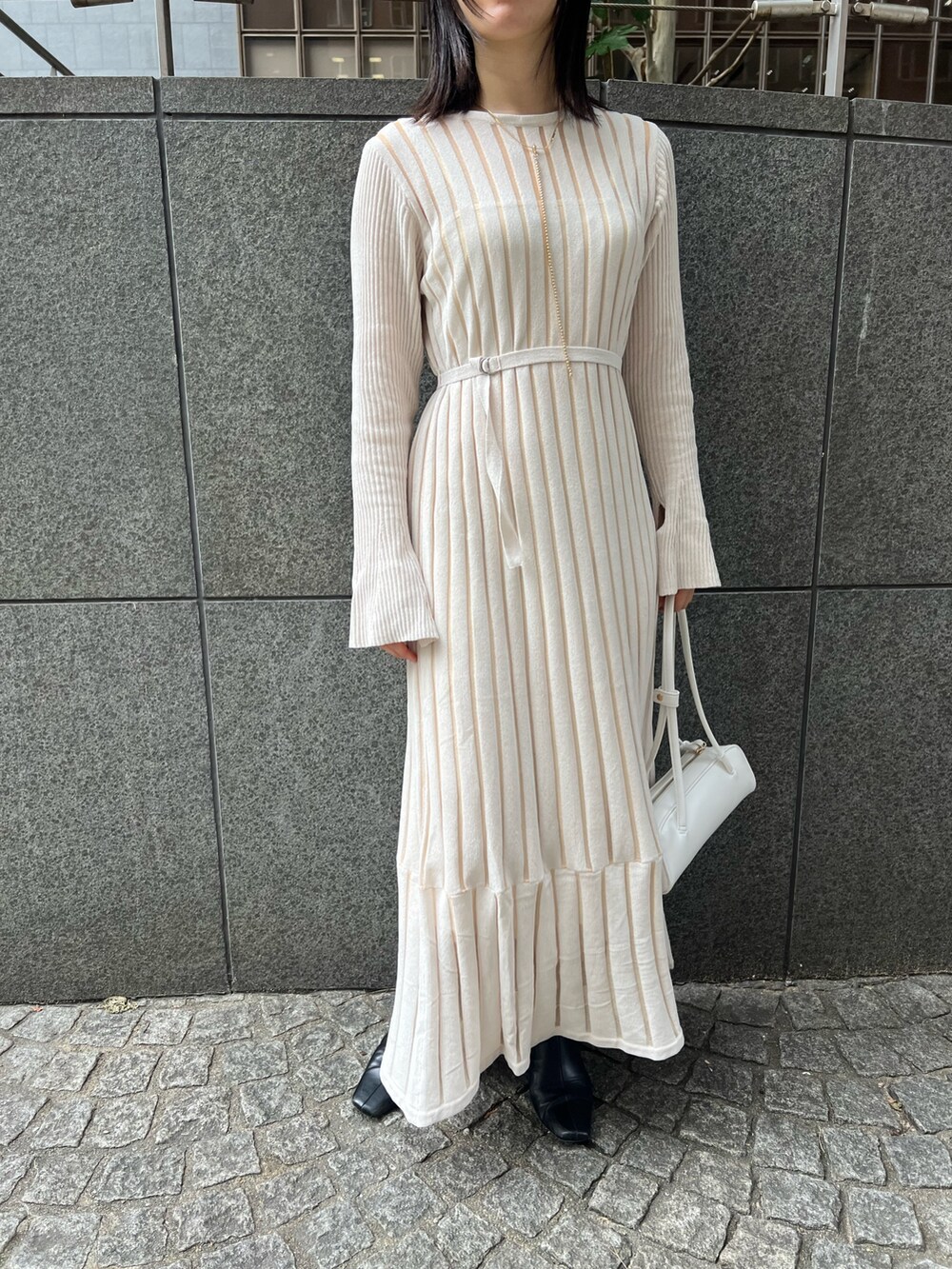 ブラック系のブーツ、ホワイト系のカーディガン/ボレロ、ホワイト系のショルダーバッグを着用したレディースの秋コーディネートの6枚目の写真