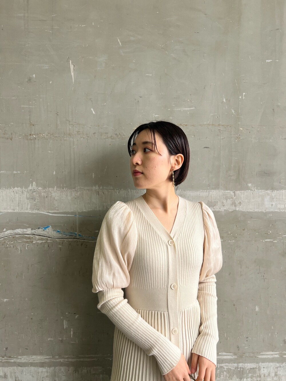 ベージュ系のブーツ、ホワイト系のワンピース、ベージュ系のハンドバッグを着用したレディースの冬コーディネートの5枚目の写真