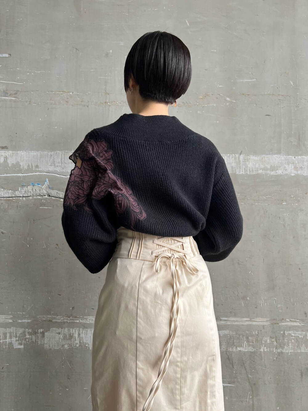 レッド系のブーツ、ホワイト系のスカート、ブラウン系のブルゾンを着用したレディースの冬コーディネートの7枚目の写真