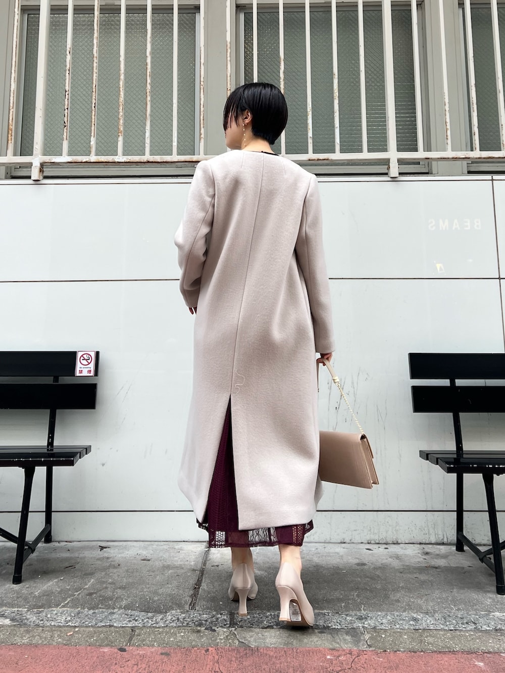 ホワイト系のノーカラーコート、レッド系のドレス、ベージュ系のパンプスを着用したレディースの冬コーディネートの3枚目の写真