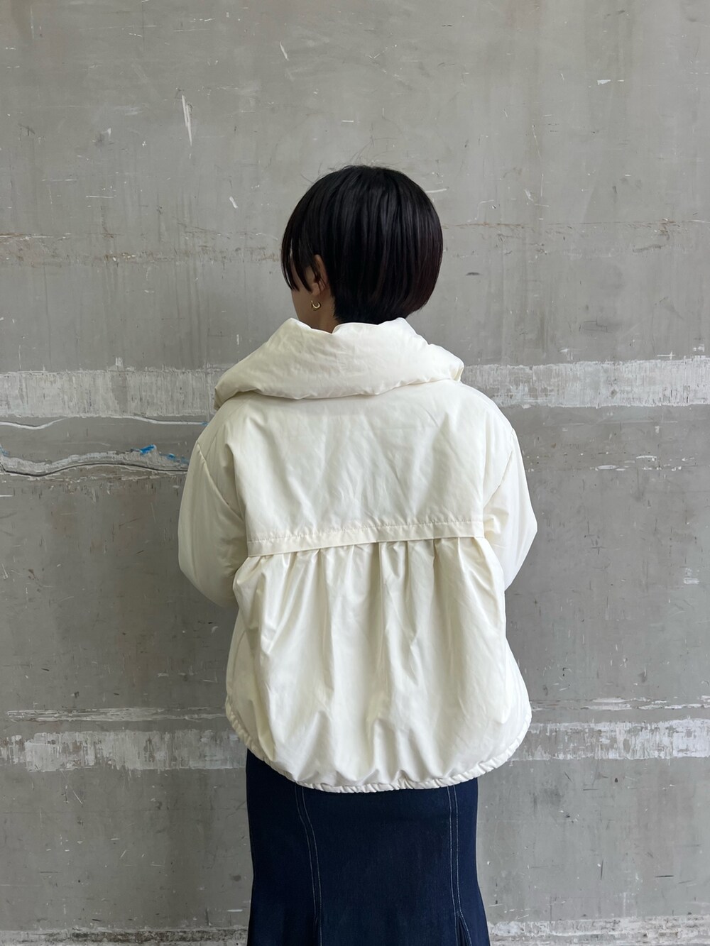 ベージュ系のブーツ、ブルー系のスカート、ホワイト系のダウンジャケット/コートを着用したレディースの冬コーディネートの4枚目の写真