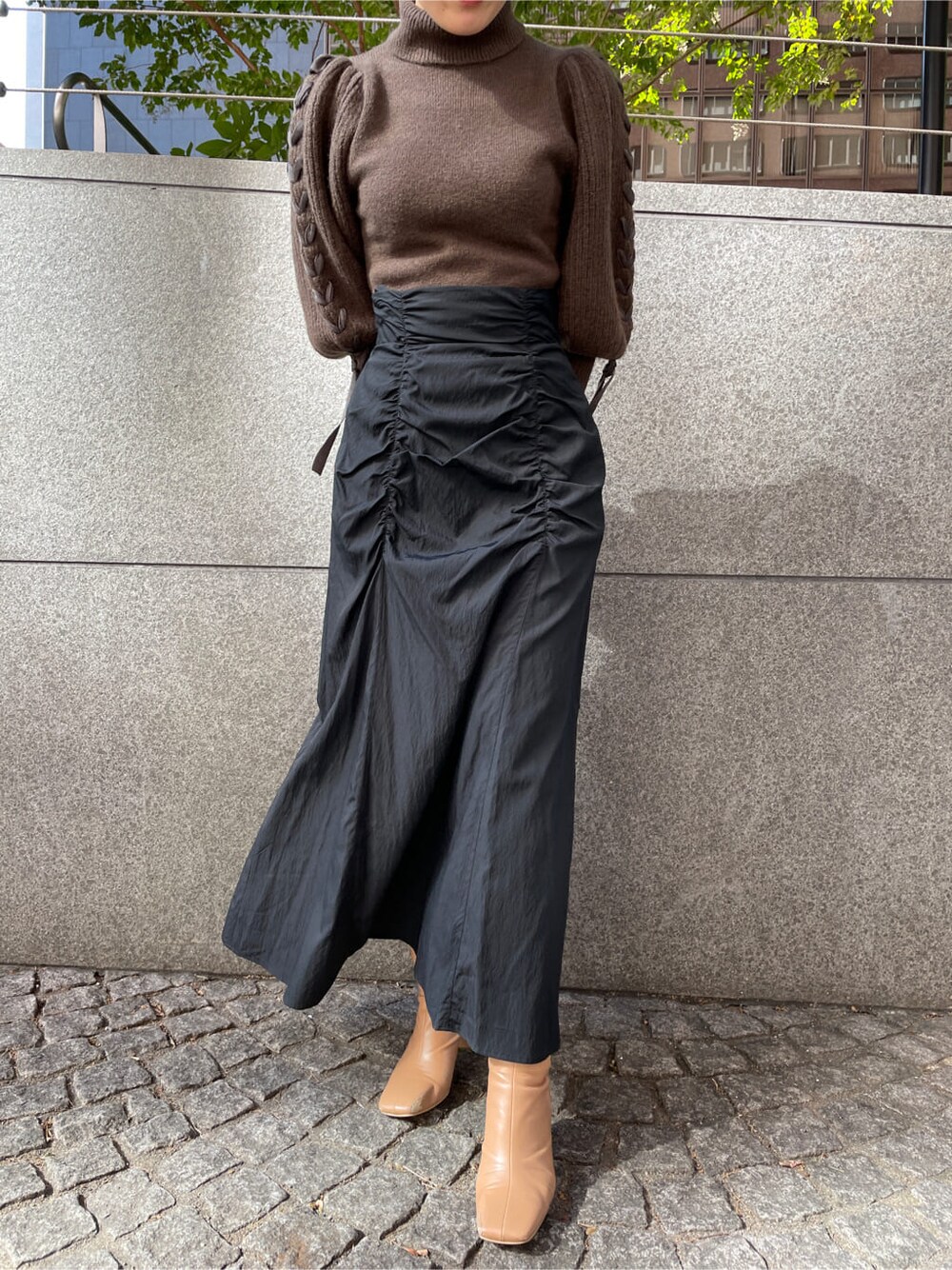 ベージュ系のその他シューズ、ホワイト系のその他アウター、ブラック系のスカートを着用したレディースの秋コーディネートの5枚目の写真