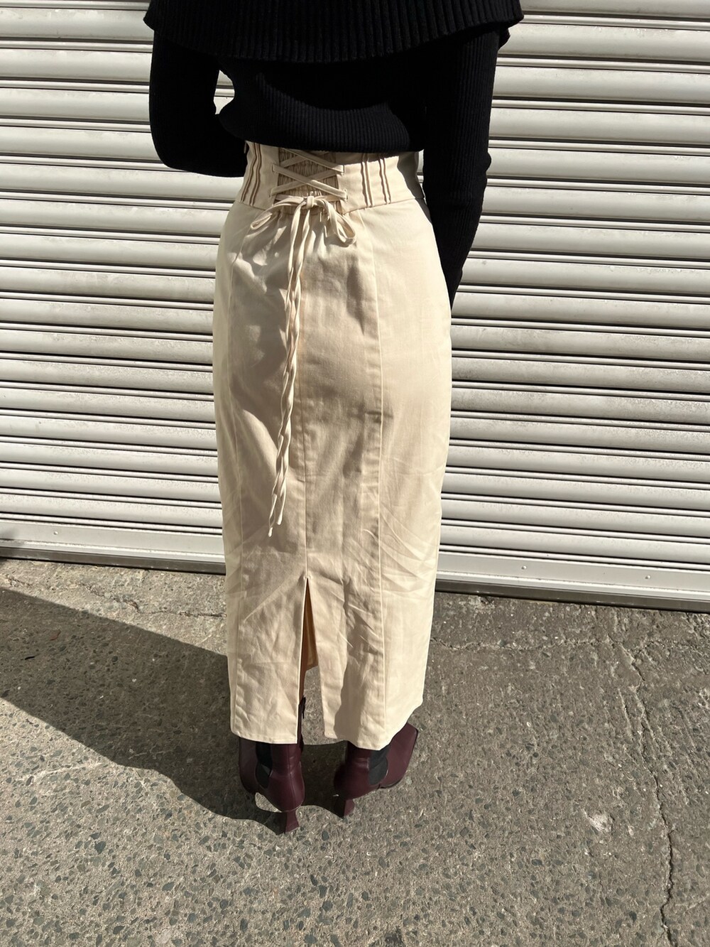 レッド系のブーツ、ホワイト系のスカート、ホワイト系のカーディガン/ボレロを着用したレディースの冬コーディネートの8枚目の写真