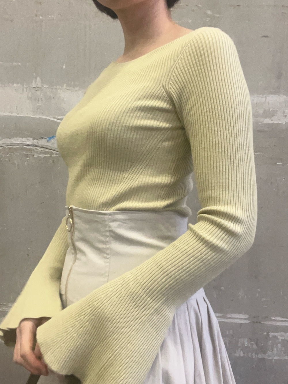 ベージュ系のブーツ、ホワイト系のスカート、グリーン系のニット/セーターを着用したレディースの冬コーディネートの5枚目の写真