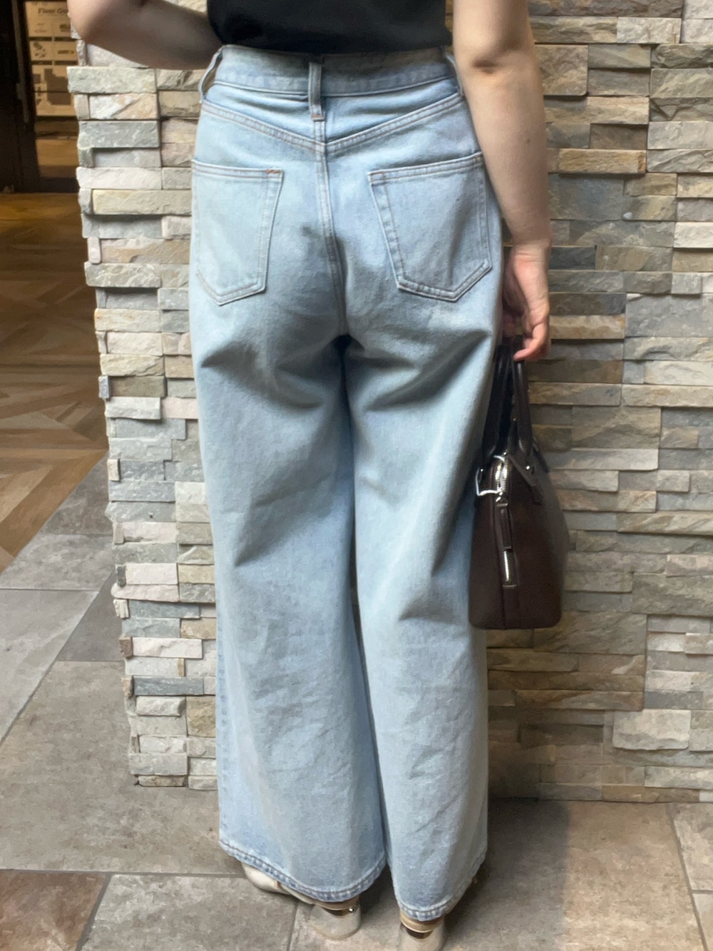 ブラック系のニット/セーター、ベージュ系のパンプス、ブラウン系のボストンバッグを着用したレディースの夏コーディネートの6枚目の写真