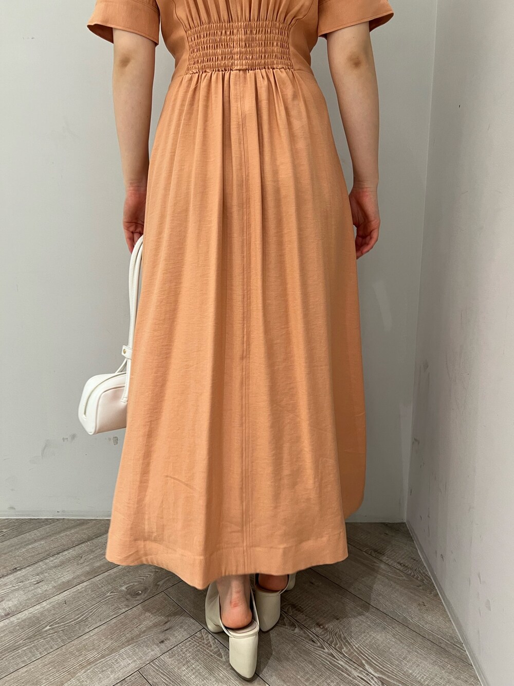 オレンジ系のワンピース、ホワイト系のサンダルを着用したレディースの春コーディネートの8枚目の写真