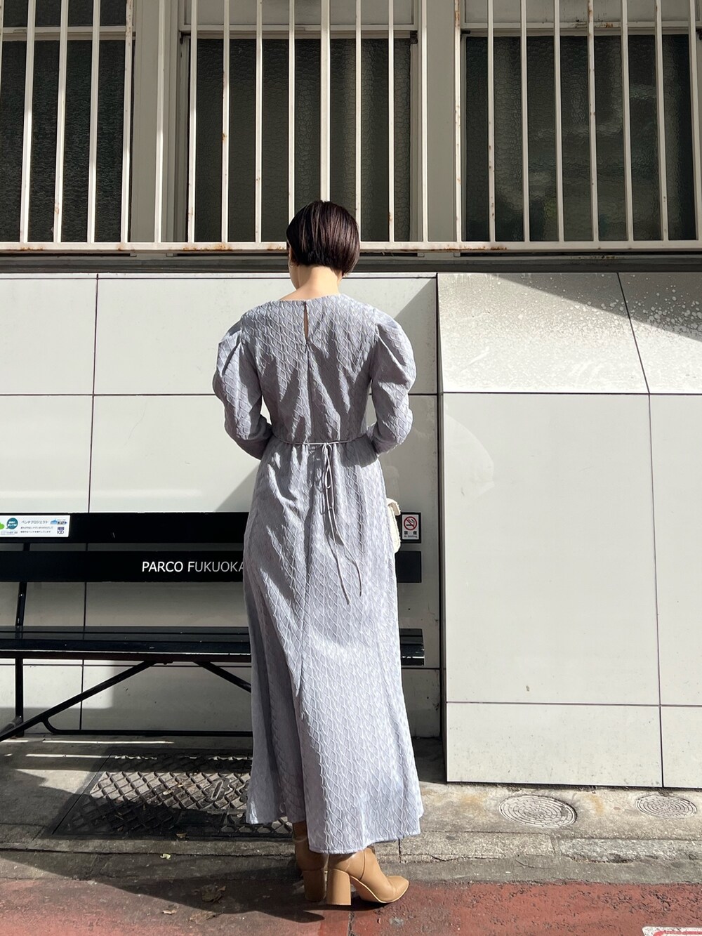 ホワイト系のショルダーバッグ、ベージュ系のブーツ、ベージュ系のその他アウターを着用したレディースの冬コーディネートの7枚目の写真