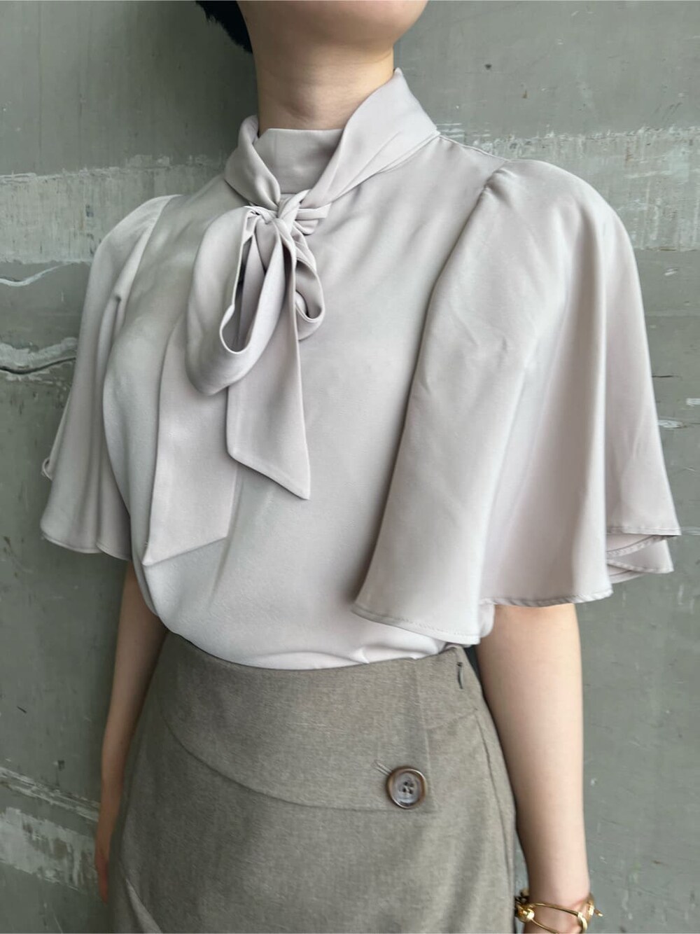 ベージュ系のハンドバッグ、レッド系のサンダル、ベージュ系のスカートを着用したレディースの夏コーディネートの6枚目の写真