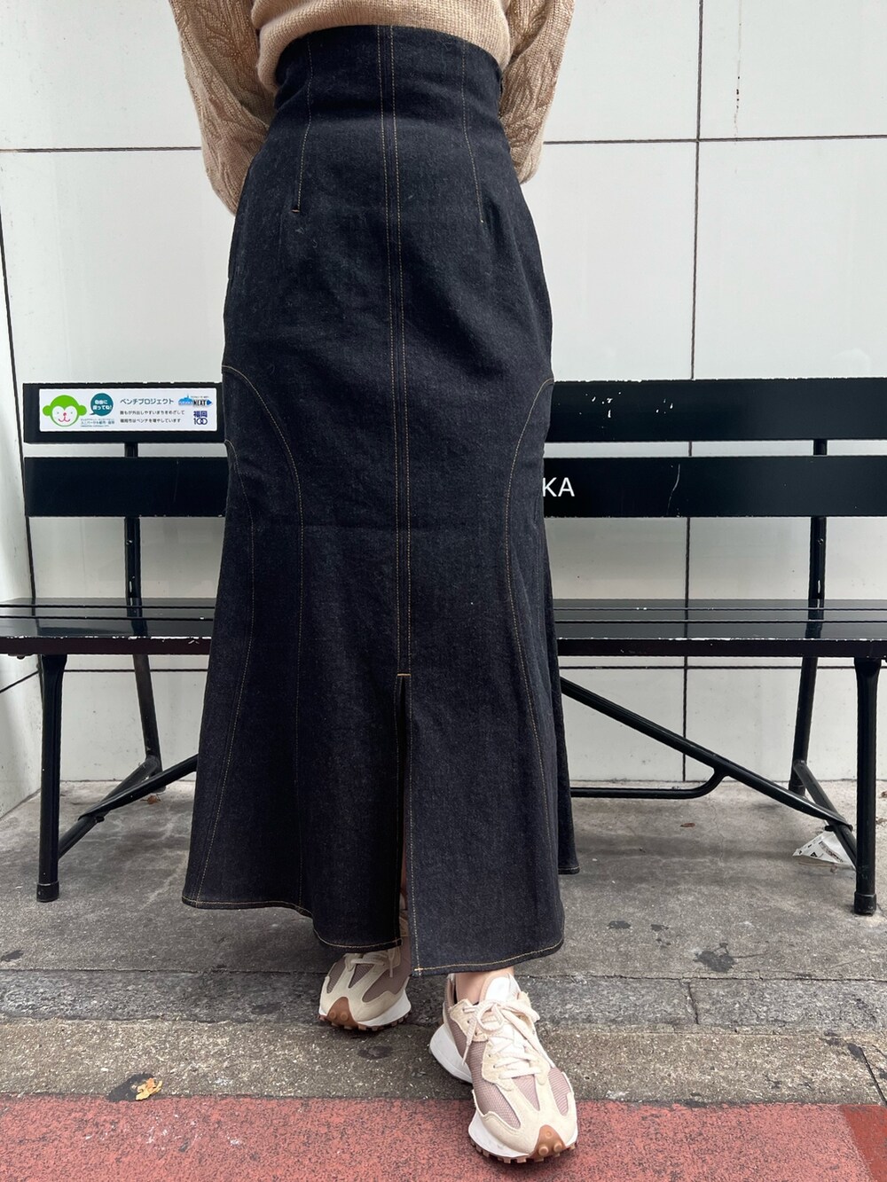 ベージュ系のスニーカー、グリーン系のカーディガン/ボレロ、ブラック系のデニムスカートを着用したレディースの秋コーディネートの9枚目の写真