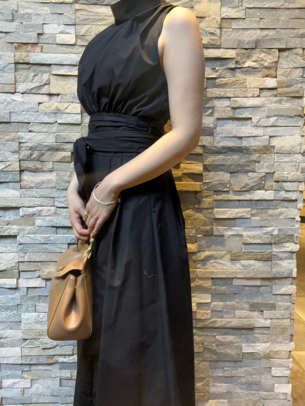 ブラック系のワンピース、ホワイト系のサンダル、レッド系のハンドバッグを着用したレディースの夏コーディネートの5枚目の写真