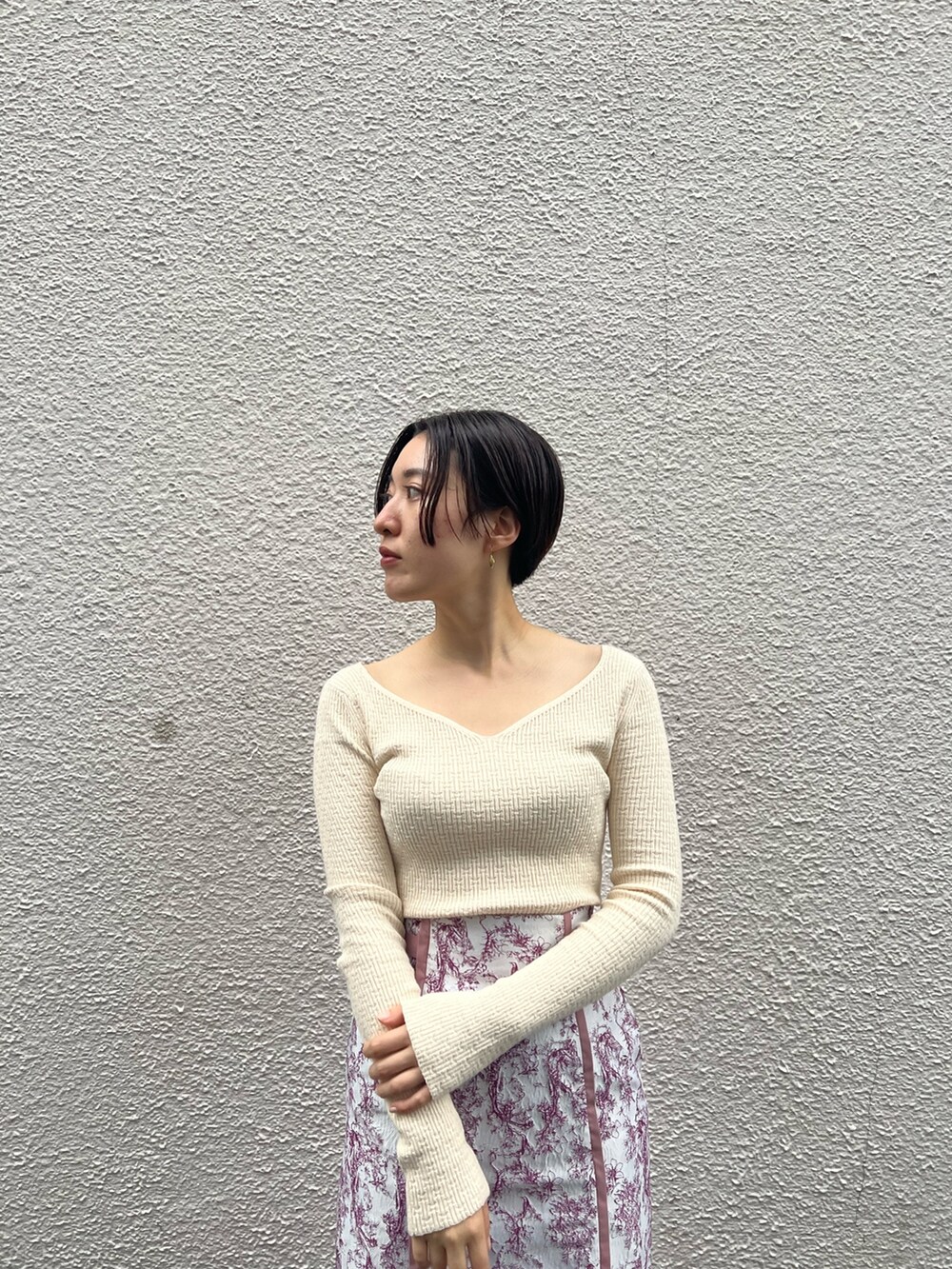 ベージュ系のブーツ、ベージュ系のその他アウター、ホワイト系のニット/セーターを着用したレディースの秋コーディネートの6枚目の写真